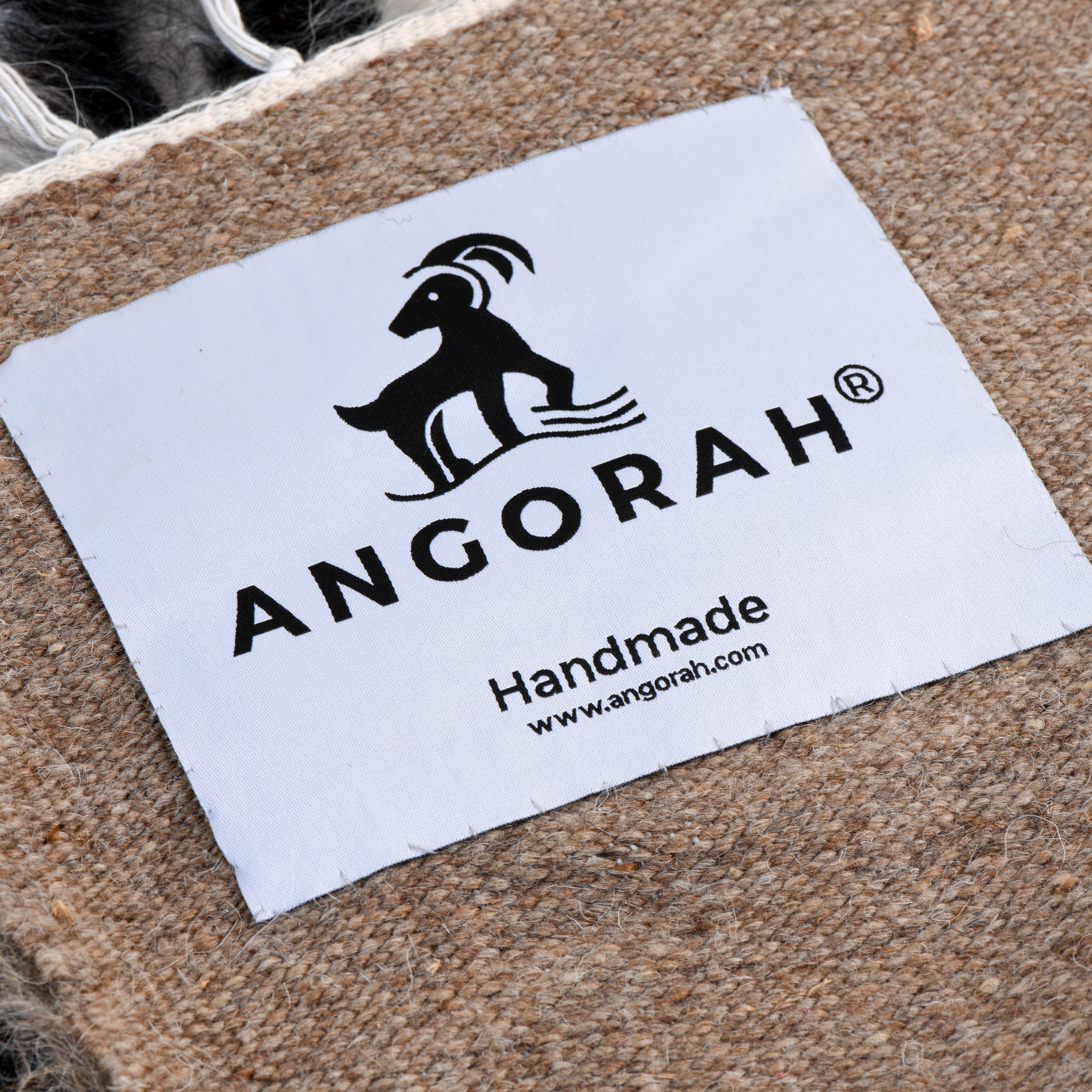 Close-up of the Angorah label on the Nordlys organic mohair rug, emphasizing the handcrafted quality and sustainable luxury of this Scandinavian-inspired piece.