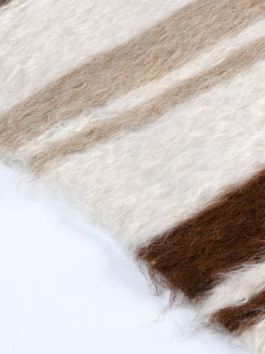 Close-up of the Linjeflod rug edge, showcasing the natural mohair fibers in earthy browns, grays, and whites, handwoven with a Scandinavian design influence